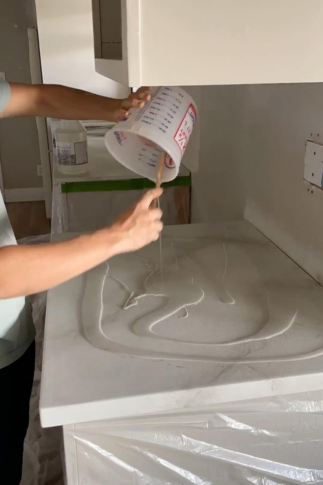 Pouring epoxy on DIY kitchen countertop.